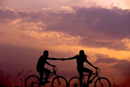 Couple holding hands on bicycles