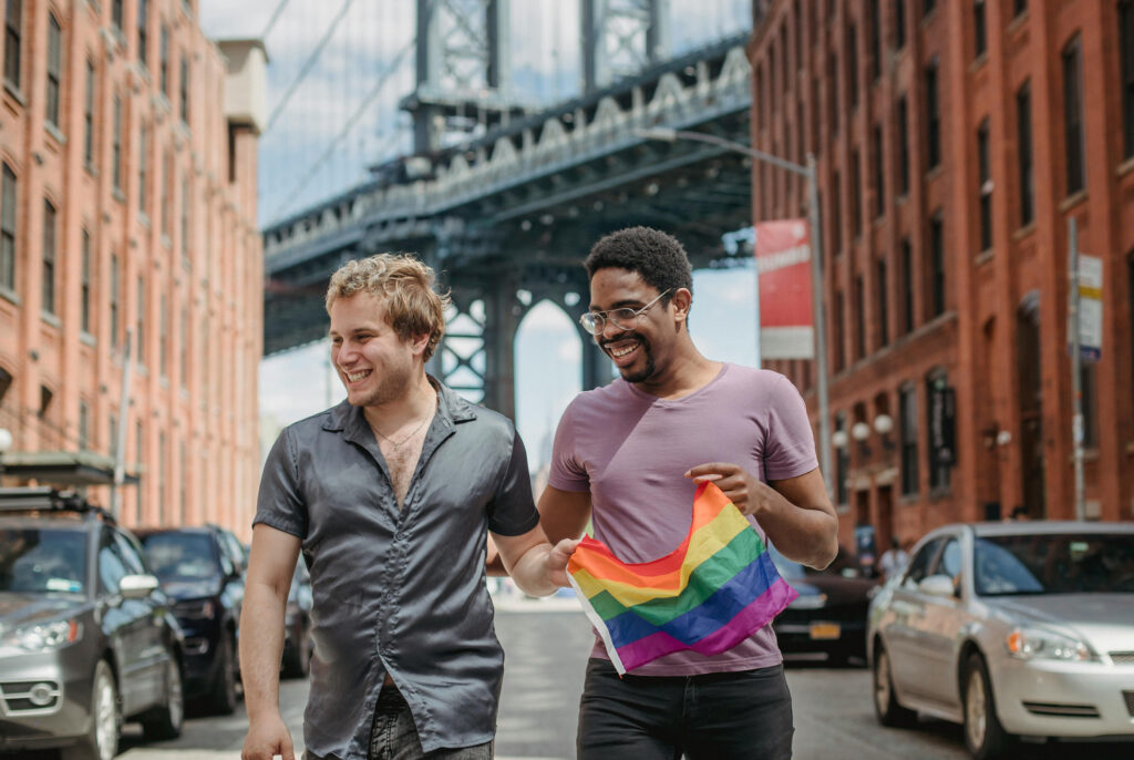 Two queer men with a rainbow flag in new york city